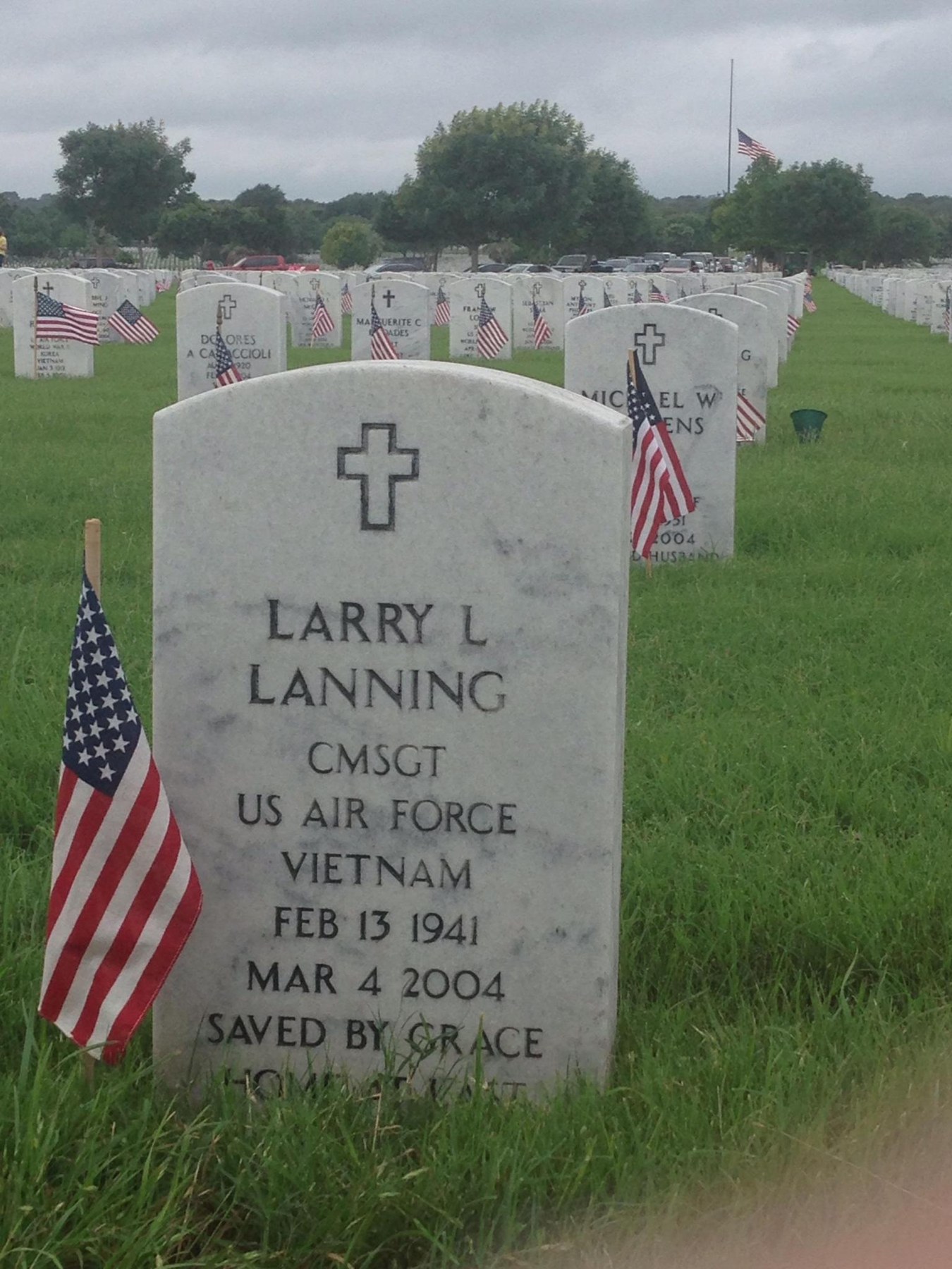 Larry Lanning headstone at a cemetery with American flags